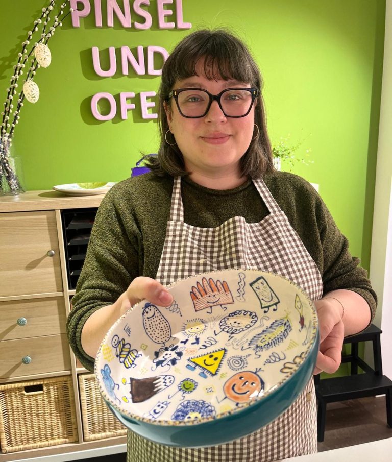 Eine Person hält drei Stapelpakete vor sich.